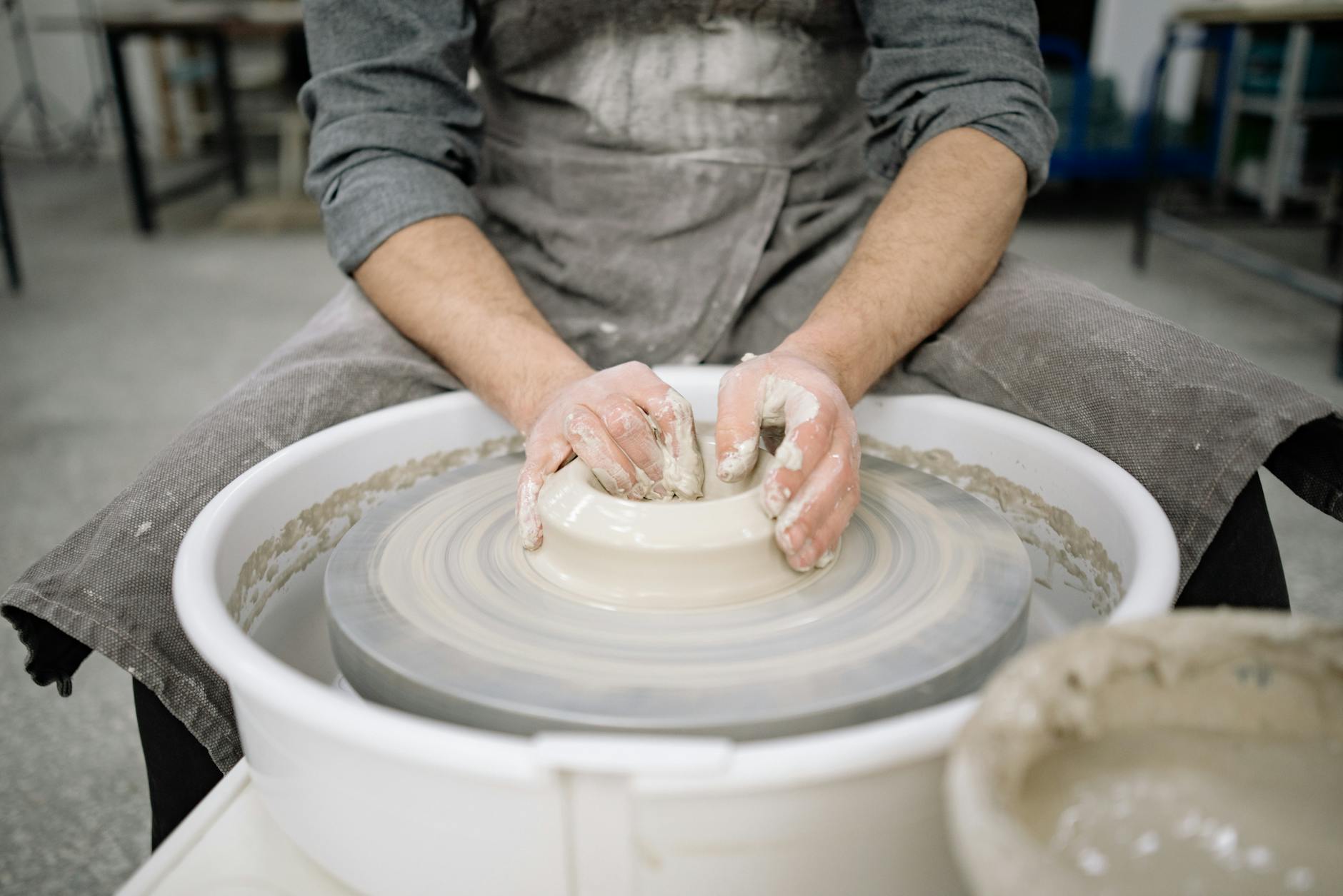 A potter expertly shaping clay on a ceramic wheel, showcasing the artistry and skill of pottery crafting.